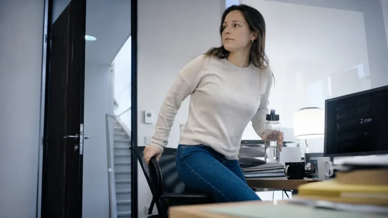 Femme se lève pour bouger plus au quotidien au bureau